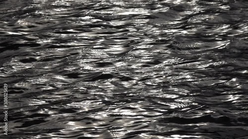Slow motion of fluent ripple on dark water surface. Amazing meditative background for excellent intro in hypnotic style. Liquid metal mirror with natural beautiful contrast pattern.