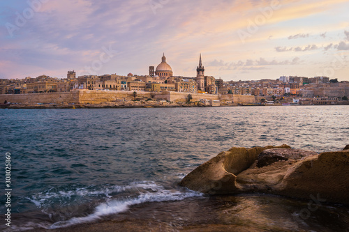 Malta. Valletta seafront at sunset with Basilica of Our Lady of Mount Carmel, viewed from Sliema.