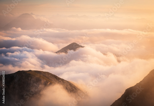 Über den Wolken im Abendrot auf einem Gipfel der Alpen