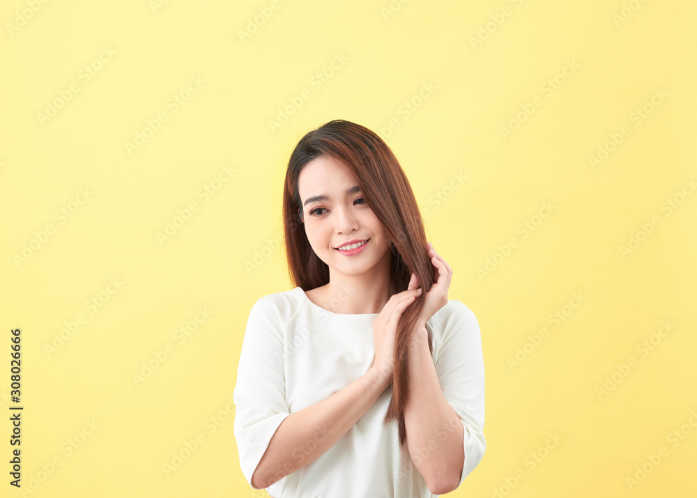 Beauty woman touch her long hair isolated on yellow background, asian beauty Beauty woman touch her long hair isolated on yellow background, asian beauty