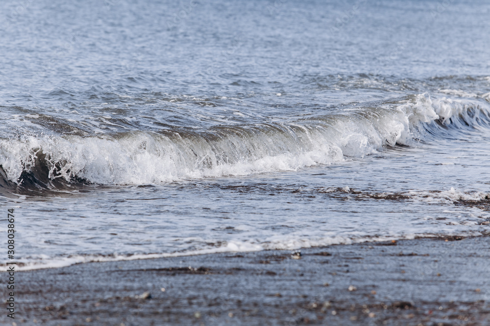 Fototapeta premium Waves on the beach. A surge of water ashore.