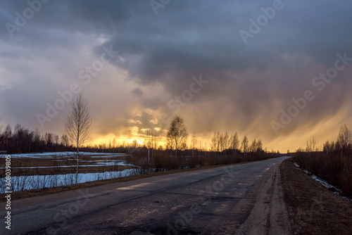 The road going into the distance against the backdrop of storm clouds at sunset  © Andrey Nikitin
