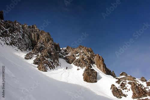 View of snowboarder walking down the mountain side