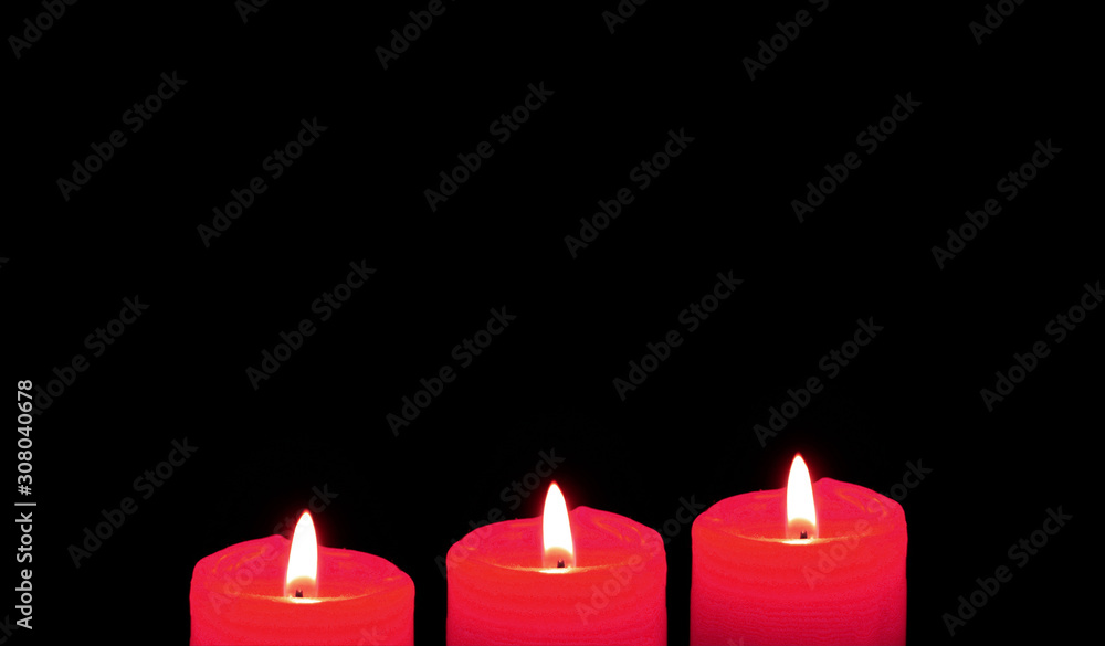 Glowing red candles on the black background with copy space Glowing red candles on the black background with copy space