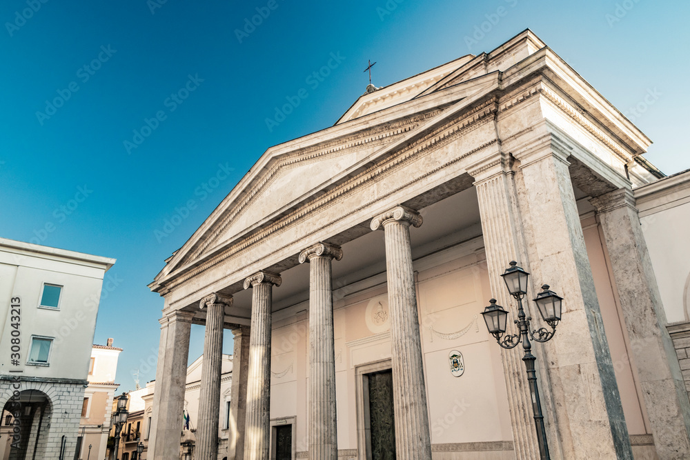 The cathedral of San Pietro Apostolo in Isernia. The facade with a large triangular tympanum in travertine, supported by pillars and columns with Ionic capitals. The portal with bas-reliefs.