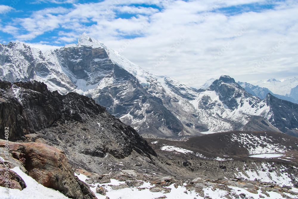 View of Lobuche mountain peak from Cho La pass in Sagarmatha national park in Himalayas in cloudy day. The summit is covered with a thick layer of ice. Route to Everest base camp through Gokyo lakes.