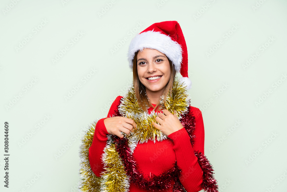 Girl with christmas hat over isolated green background Girl with christmas hat over isolated green background