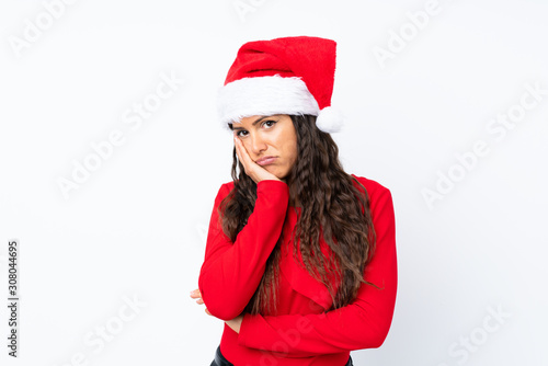 Girl with christmas hat over isolated white background unhappy and frustrated
