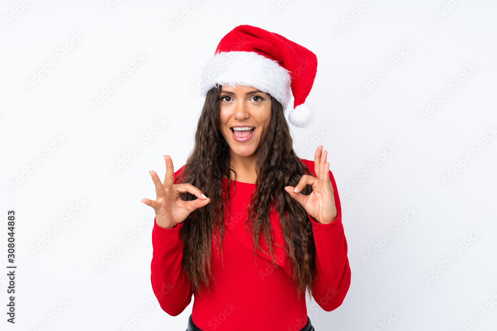 Girl with christmas hat over isolated white background showing an ok sign with fingers Girl with christmas hat over isolated white background showing an ok sign with fingers