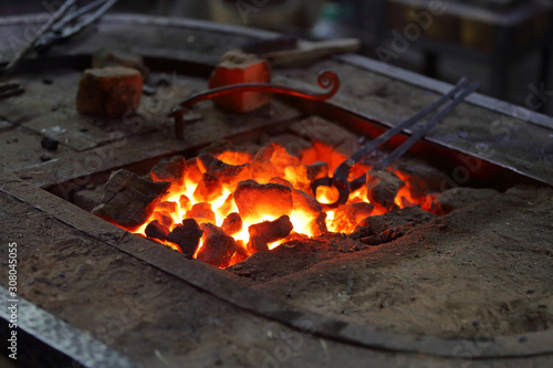 Hot coals in a furnace for heating metal for manual forging in a blacksmith workshop