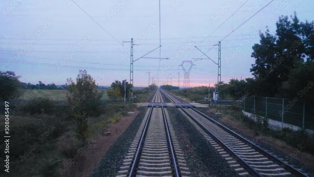 View over railroad tracks as seen from a moving train during sunrise View over railroad tracks as seen from a moving train during sunrise