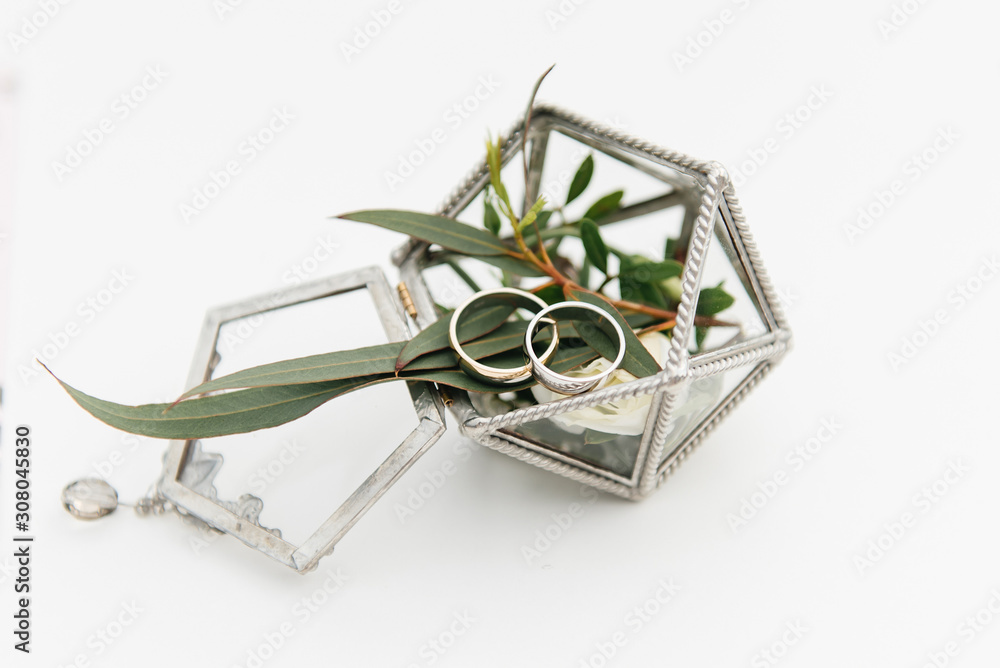 Fototapeta premium Wedding rings in a box with flowers, decor and details of the wedding ceremony, selective focus, macro