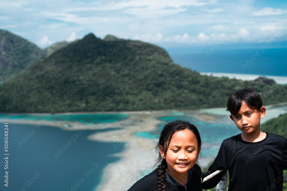 Asian kids standing on top of the mountain of Bohey Dulang in Semporna, Sabah.