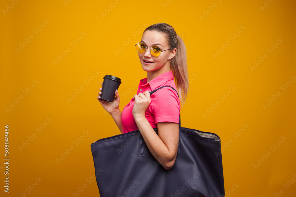 Business positive girl in casual style hurries on business and drinks coffee to take away. Coffee break Business positive girl in casual style hurries on business and drinks coffee to take away. Coffee break