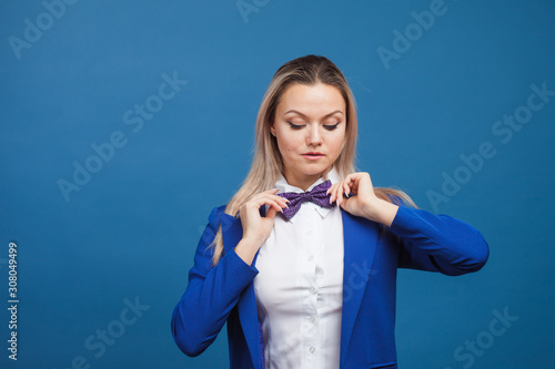 Happy smiling young woman in blue on blue background. Friendly business portrait