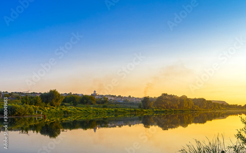 Beautiful sunset over the river and village. The Church is visible in the background.