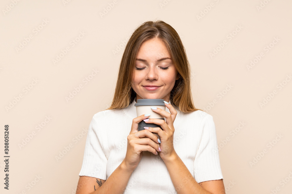 Young blonde woman over isolated background holding coffee to take away Young blonde woman over isolated background holding coffee to take away