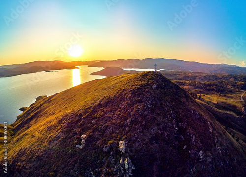 Beautiful futuristic panoramic aerial drone view to summer recreation facilities on the banks of the Bukhtarma reservoir on the Irtysh river with an Orthodox cross on top of mountain, East Kazakhstan photo