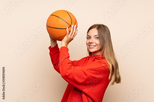 Young blonde woman over isolated background with ball of basketball © luismolinero