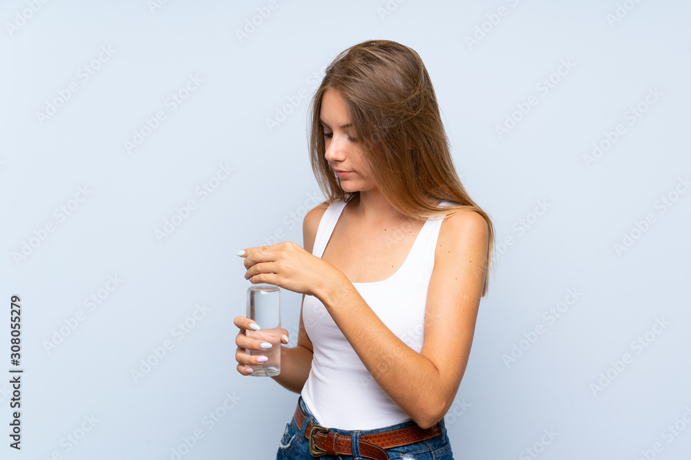 Young blonde girl with a bottle of water over isolated background Young blonde girl with a bottle of water over isolated background