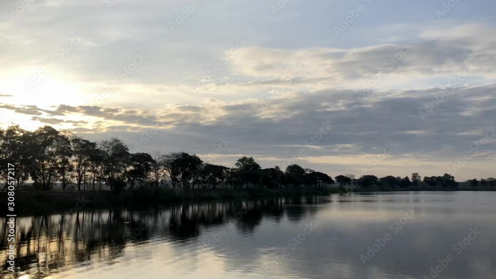 Sunrise in the morning Shine on the water surface With the sky and trees in the background Sunrise in the morning Shine on the water surface With the sky and trees in the background