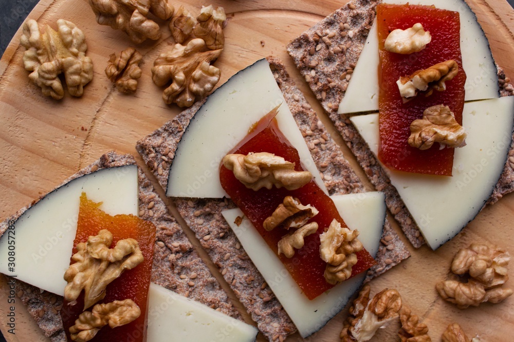 Wood plate with cheese, nuts and quince jelly on top of toasted bread. Healthy food. Wood plate with cheese, nuts and quince jelly on top of toasted bread. Healthy food.