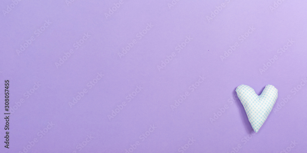 Valentine's day heart shaped pillow on a purple paper background Valentine's day heart shaped pillow on a purple paper background