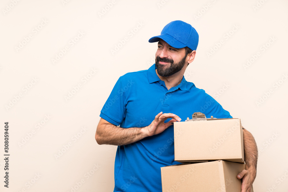 Delivery man with beard over isolated background scheming something Delivery man with beard over isolated background scheming something