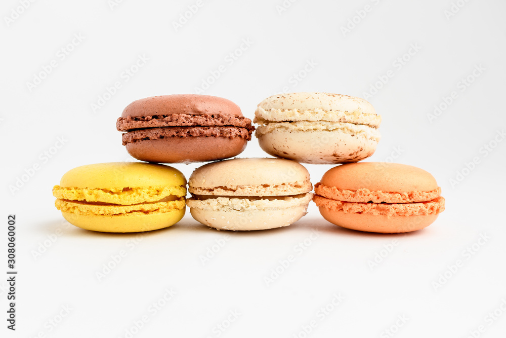 Close up of row of five sweet French macarons with different aromas, isolated on white, flavours of orange, lemon, caramel, vanilla and coconut pastel colors of freshly tasty dessert Close up of row of five sweet French macarons with different aromas, isolated on white, flavours of orange, lemon, caramel, vanilla and coconut pastel colors of freshly tasty dessert