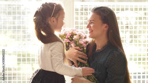 Child daughter congratulates moms and gives her a gift box. Happy mother's day