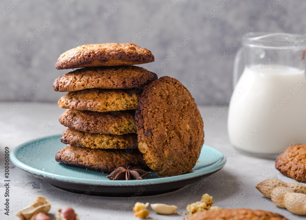 Homemade organic oatmeal cookies with peanuts and bottle of milk on light concrete background. Homemade organic oatmeal cookies with peanuts and bottle of milk on light concrete background.