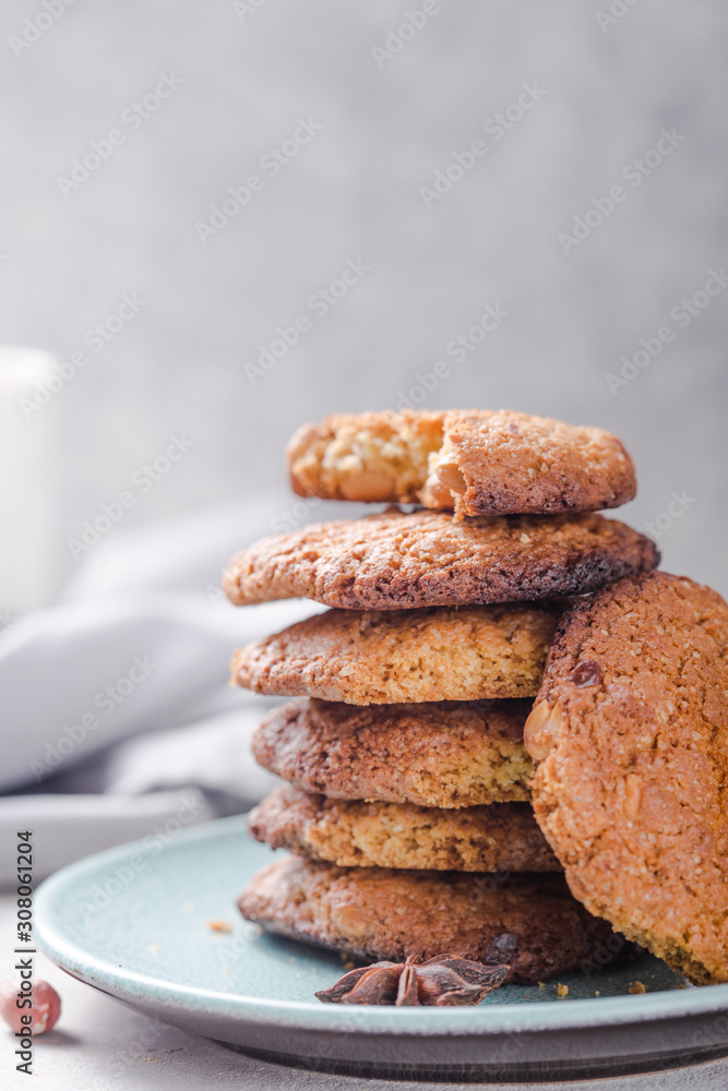 Homemade organic oatmeal cookies with peanuts and bottle of milk on light concrete background. Homemade organic oatmeal cookies with peanuts and bottle of milk on light concrete background.