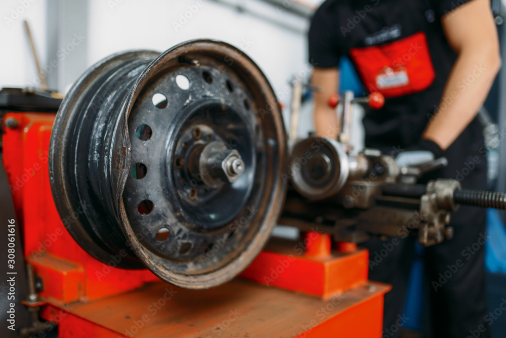 Repairman works with crumpled disc, tire service Repairman works with crumpled disc, tire service