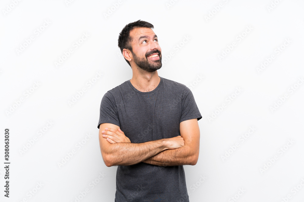 Young handsome man over isolated white background looking up while smiling Young handsome man over isolated white background looking up while smiling