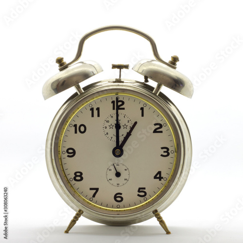Old-style alarm clock, metal, it's one o'clock.