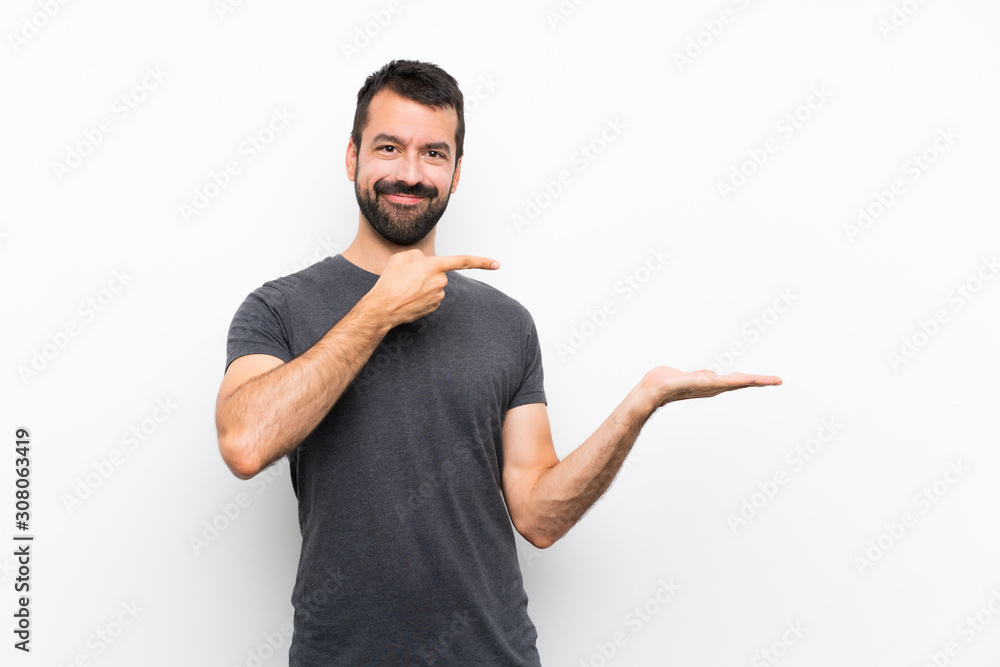 Young handsome man over isolated white background holding copyspace imaginary on the palm to insert an ad Young handsome man over isolated white background holding copyspace imaginary on the palm to insert an ad
