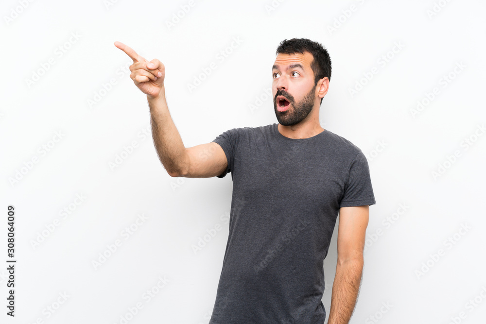 Young handsome man over isolated white background pointing away Young handsome man over isolated white background pointing away