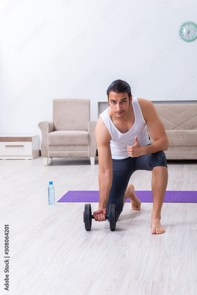 Fototapeta premium Young man training and exercising at home