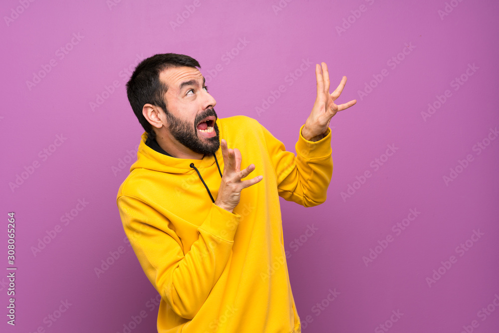 Handsome man with yellow sweatshirt nervous and scared Handsome man with yellow sweatshirt nervous and scared
