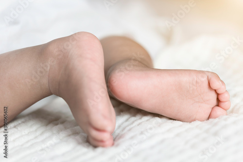 Newborn baby feet on a white blanket. © Kung37