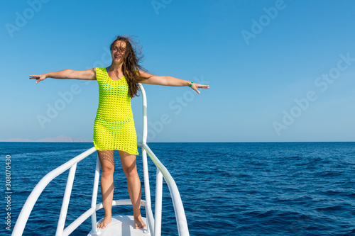 Happy woman with long hair is relaxing on a yacht. Sea vacation concept. copy space