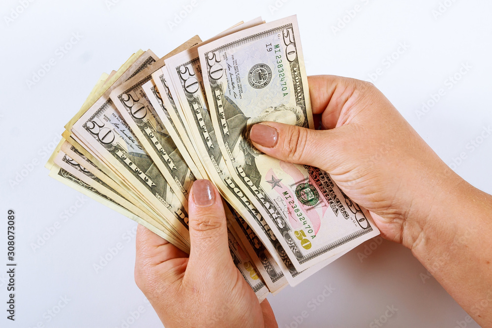 Woman's hands counting dollar bills on a white background. Woman's hands counting dollar bills on a white background.