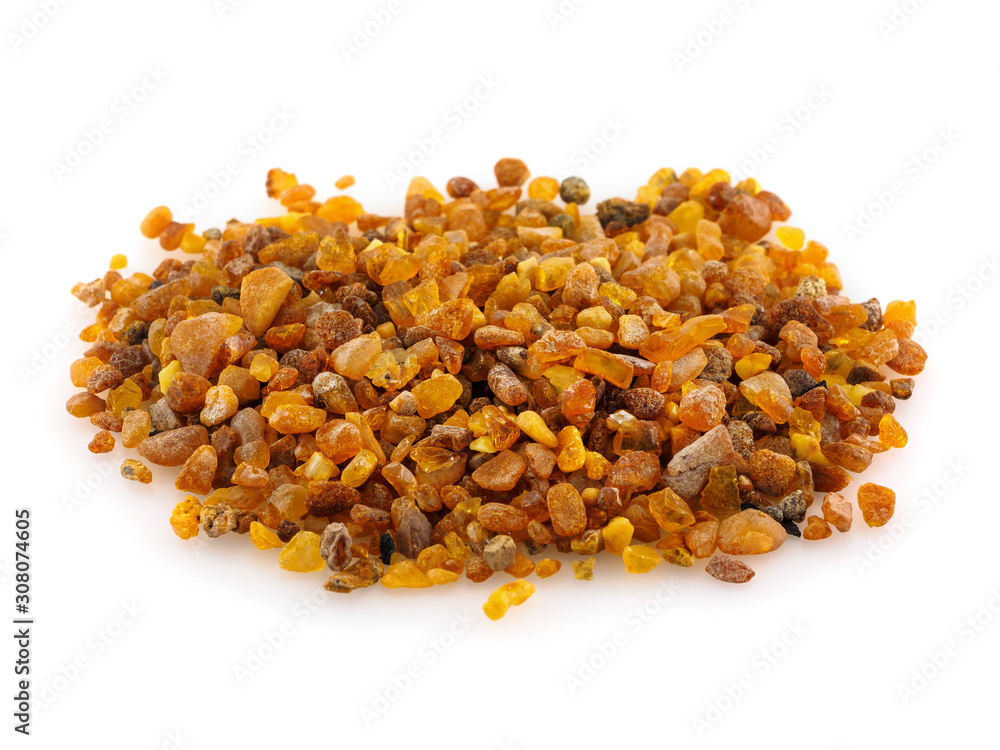 A pile of amber stones on a white background. A handful of yellow amber A pile of amber stones on a white background. A handful of yellow amber
