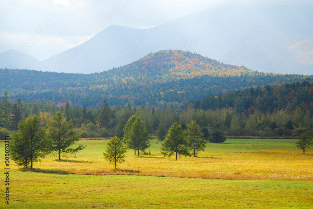landscape photo of mountains in fall time with sun rays shinning through haze landscape photo of mountains in fall time with sun rays shinning through haze