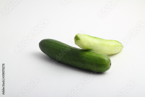 whole peeled and unpeeled fresh cucumber on white background