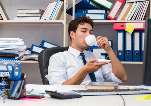 Businessman working in the office with piles of books and papers