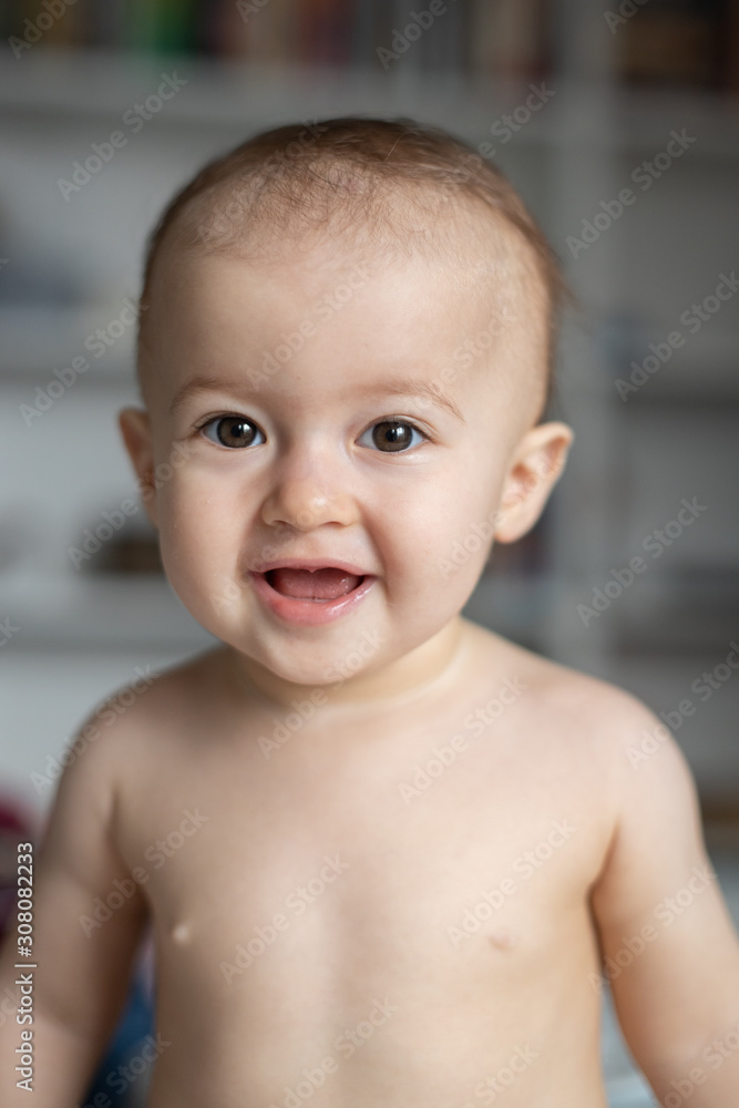 Portrait of a cute smiling baby in bedroom.