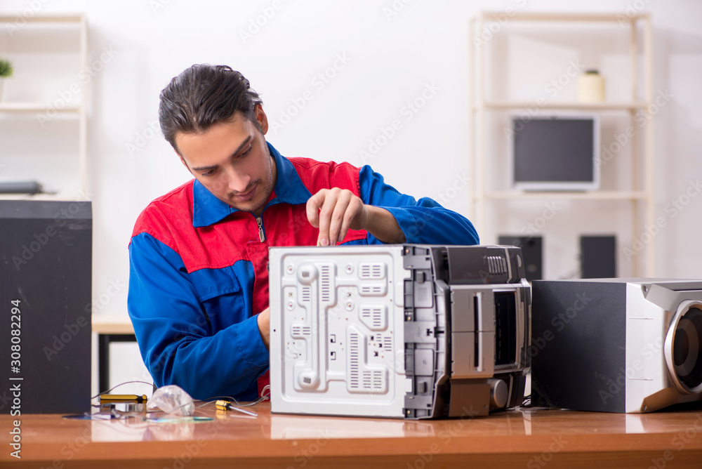 Obraz premium Young engineer repairing musical hi-fi system