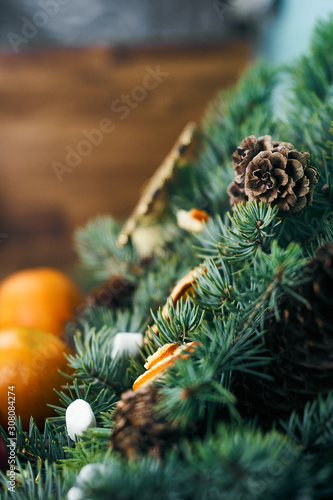 spruce branches with cones, orange slices, whole tangerines and marshmallows close-up. Christmas background
