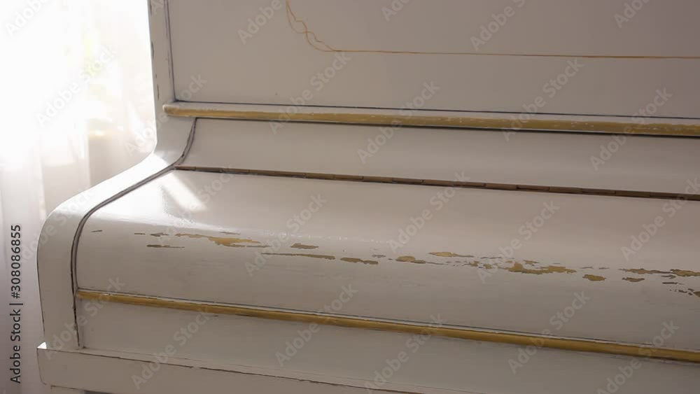White piano close-up. Sheet music lying on a white piano. White piano close-up. Sheet music lying on a white piano.